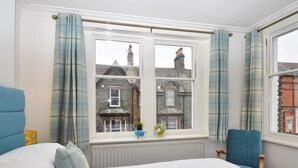 A bedroom with a large window, a bed, a chair, and a radiator. - 3 Bed in Keswick (oc-sz118) (Keswick)