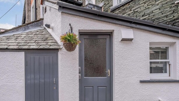 A house with a grey door, a small window, and a potted plant. - 3 Bed in Keswick (oc-sz118) (Keswick)
