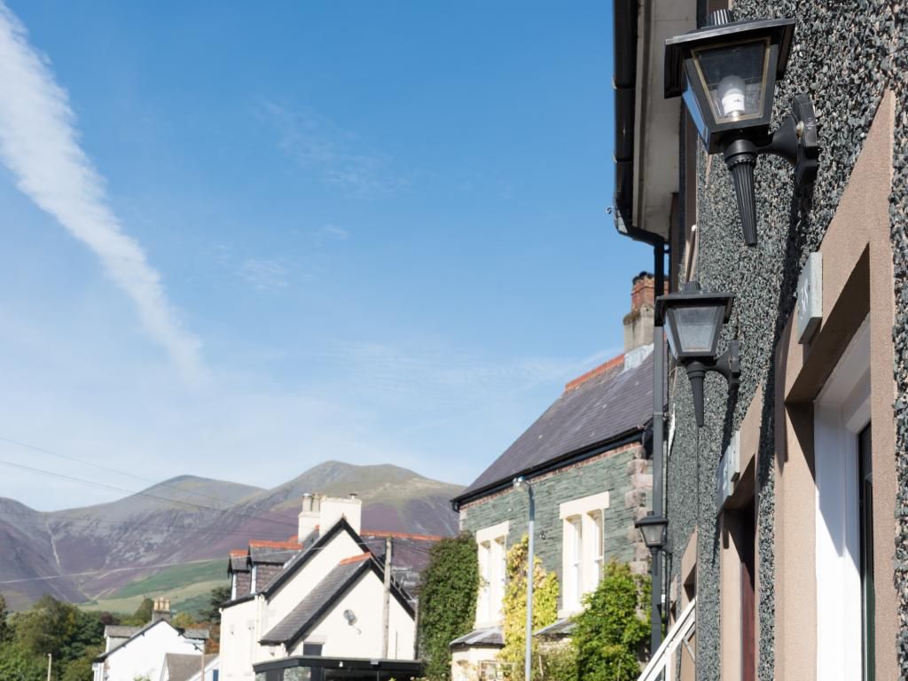 A street view with buildings, a street lamp, and mountains in the background.