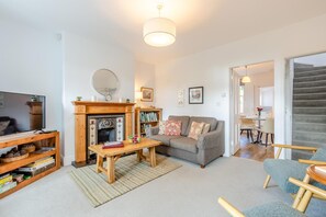 Ein Wohnzimmer mit Kamin, Sofa und Fernseher.