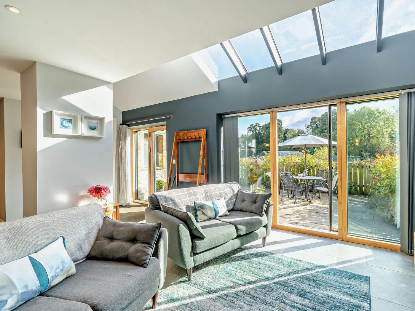 A modern living room with a large sliding glass door leading to an outdoor patio.