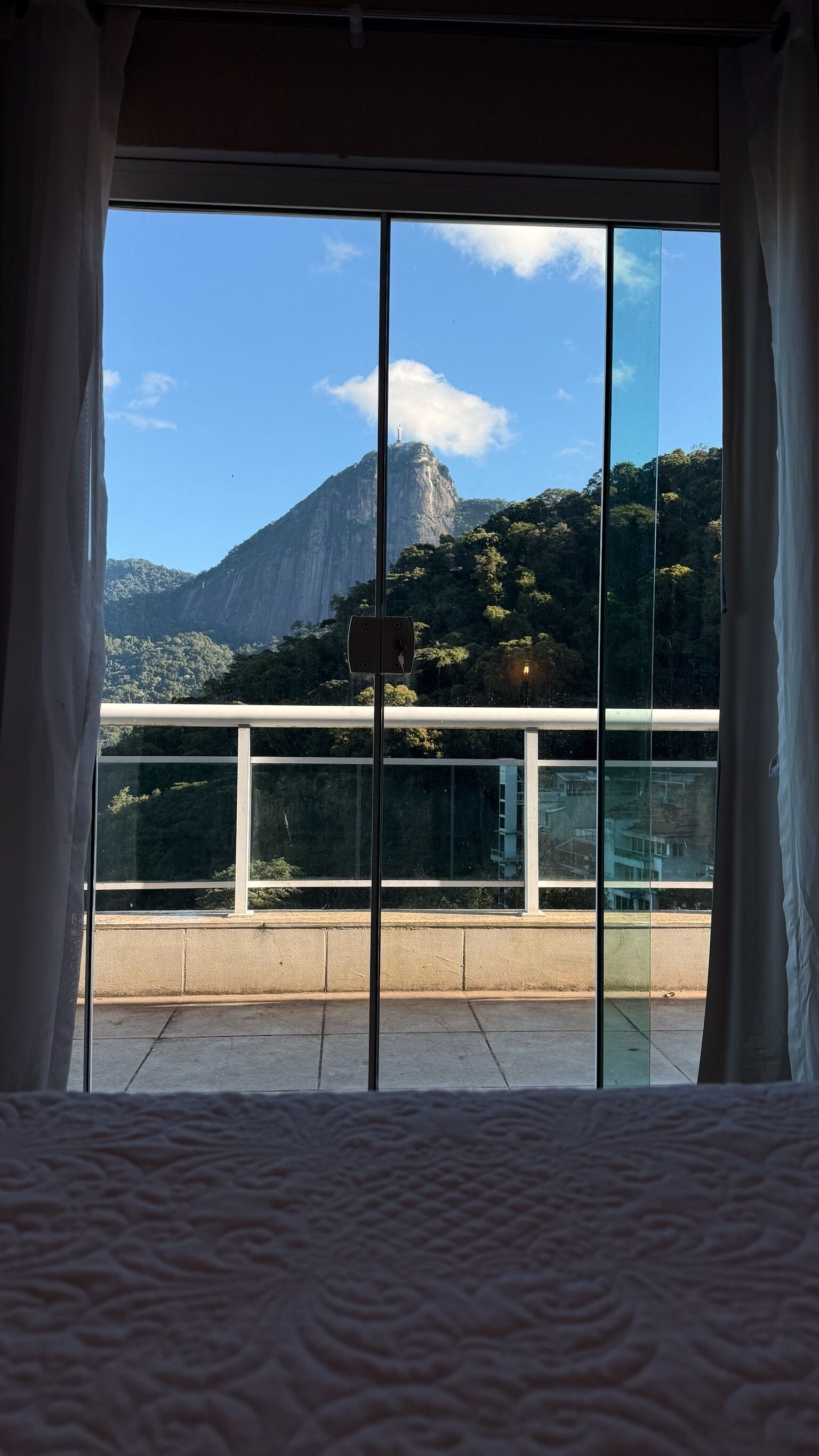Ein Zimmer mit einem großen Fenster, das einen Blick auf einen Berg und eine Brücke bietet.