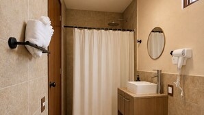 A bathroom with a shower curtain, a sink, a toilet, and a towel rack.