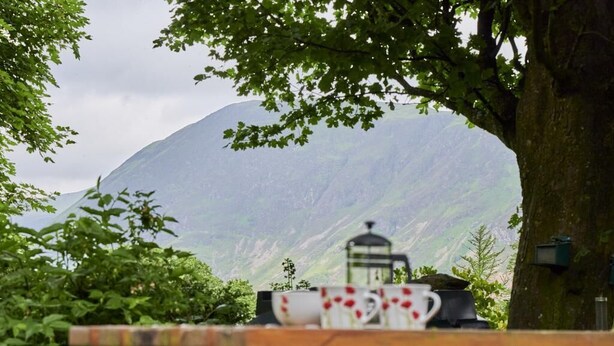 Une table avec une tasse et une soucoupe, une lanterne et une montagne en arrière-plan.