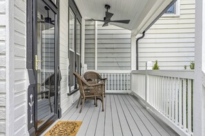 A covered porch with a ceiling fan, white railings, and wicker chairs. - The Clifton | Bars, Bourbon, and Brunch on Foot | Sleeps 15 (Louisville)