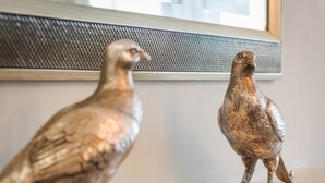 Deux statuettes d’oiseaux sont posées sur une étagère.