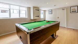 A pool table with balls, a window, and a door in a room with wooden flooring. - 5 Bed in Keswick (oc-sz291) (Keswick)