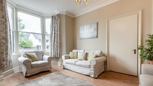 A living room with two sofas, a rug, and a door. - 5 Bed in Keswick (oc-sz291) (Keswick)