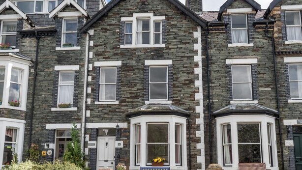 A row of stone houses with bay windows and a small garden area. - 5 Bed in Keswick (oc-sz291) (Keswick)