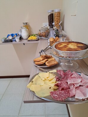 A buffet table with various food items including bread, pastries, cheese, and meats. - B&B verdi (Lecce)