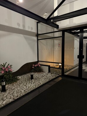 A modern building with glass doors, a stone pathway, and pink flowers. - City Centre 2-Bed Flat |
Prime Location (Salford)