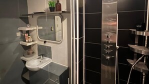 Une salle de bain moderne avec une douche à parois de verre, un lavabo et des toilettes.