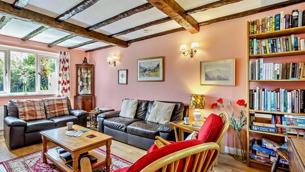 Una sala de estar acogedora con chimenea, una estantería y un espacio de asientos cómodo.