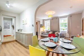 Eine moderne Küche mit Essbereich, einer Couch und Blick ins Freie.