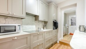 Eine moderne Küche mit integriertem Mikrowellenherd, Backofen und Schränken.