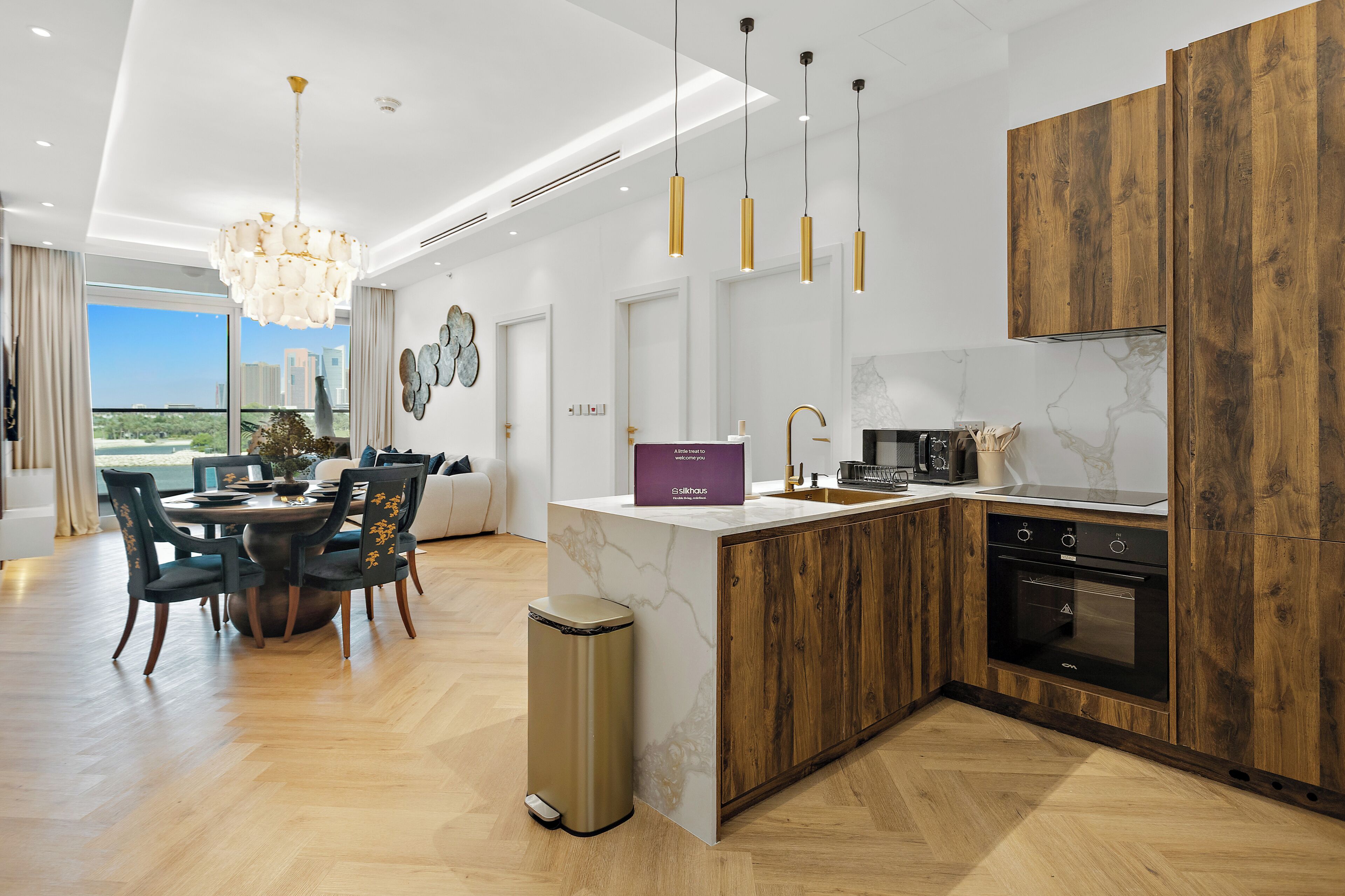 A modern kitchen with a marble countertop, wooden cabinets, and a built-in dishwasher.