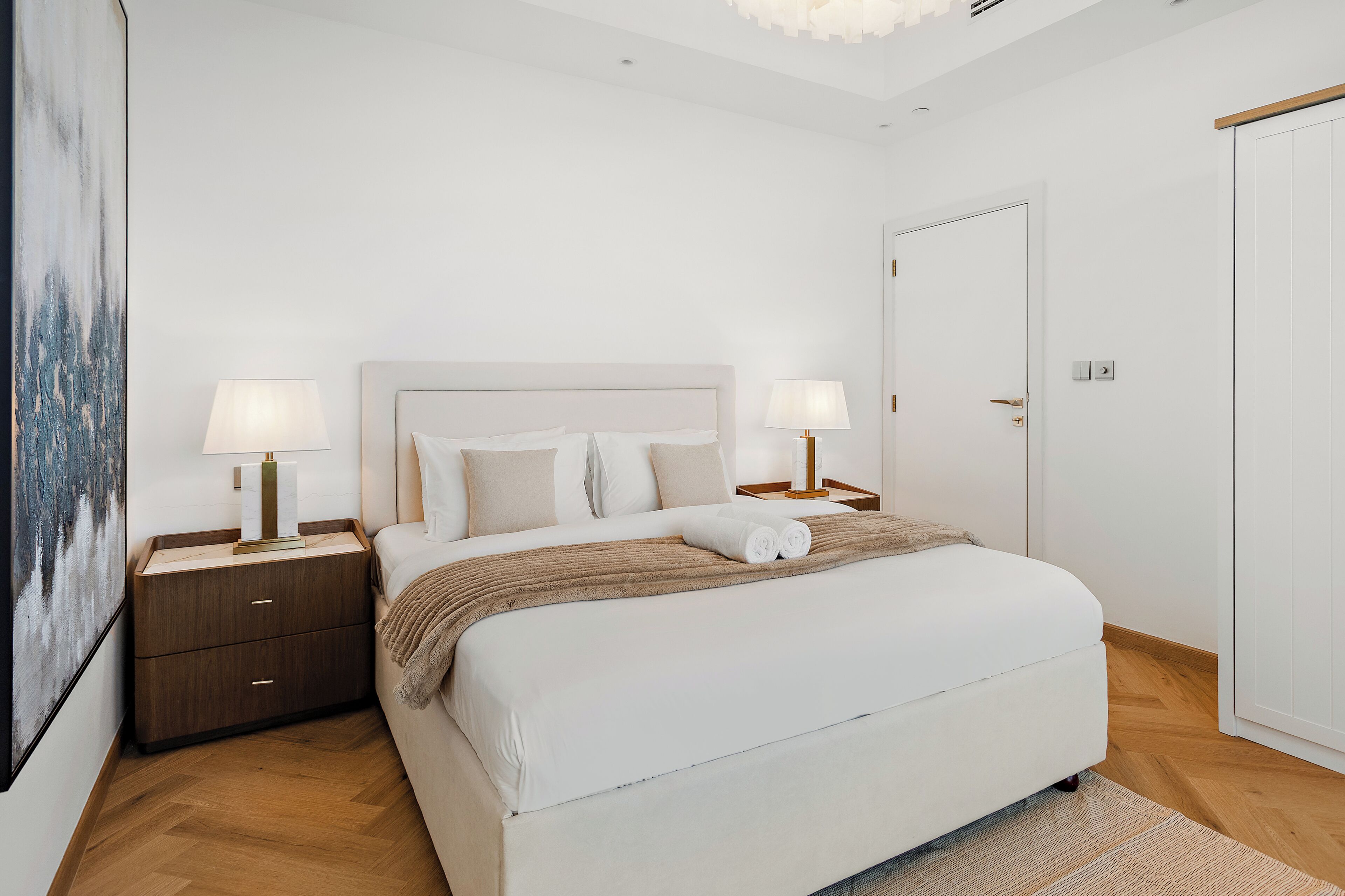 Een keurig opgeruimde slaapkamer met een groot bed, nachtkastjes en een kledingkast.