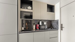 A modern kitchen with built-in appliances, a coffee machine, and a sink. - Silkhaus Hyde Walk (Dubai)