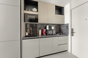 Eine moderne Küche mit eingebauten Geräten, einer Kaffeemaschine und einem Spülbecken.