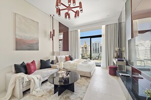 A modern living room with a sofa, coffee table, and a view of the cityscape through large windows. - Silkhaus Hyde Walk (Dubai)