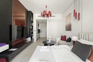 Une chambre d’hôtel moderne dotée d’un grand lit, d’un téléviseur à écran plat, d’un coin repas et d’une cuisine.