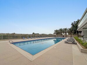 Ein Swimmingpool mit Liegestühlen und einer Palme.