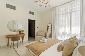 A hotel room with a bed, a desk, a chair, a mirror, and a window with curtains. - Silkhaus Polo Residence (Dubai)