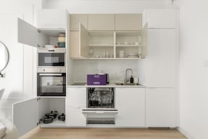 A compact kitchen with built-in appliances, including an oven and dishwasher, and a small countertop area. - Silkhaus Torche Tower (Dubai)