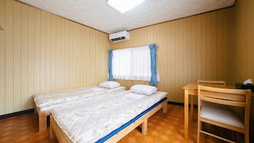 Een kamer met twee bedden, een bureau en een stoel.