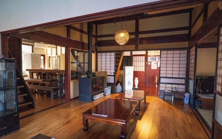 A traditional Japanese interior with tatami flooring, sliding doors, and a low wooden ceiling.