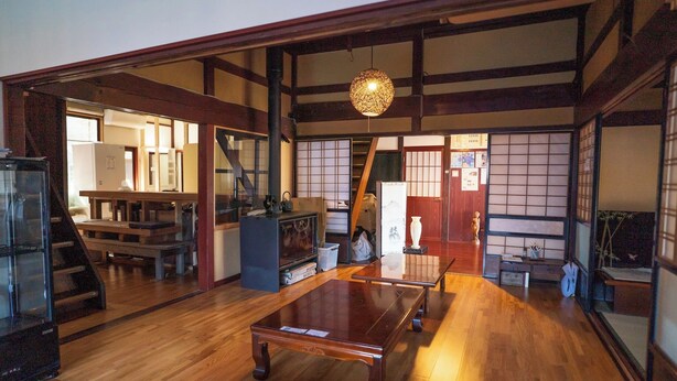A traditional Japanese interior with tatami flooring, sliding doors, and a low wooden ceiling.