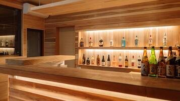 Una zona de bar con estantes de madera que exhiben varias botellas de licor.