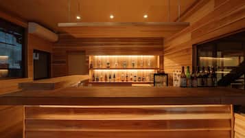 A bar area with wooden paneling and a shelf of various liquor bottles.