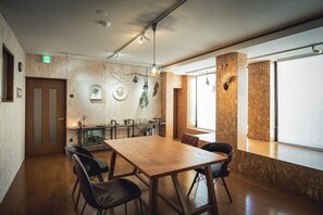 A wooden dining table with chairs, a wooden wall with a shelf, and a window with a view. - 3ldk Machiya (Matsuyama)