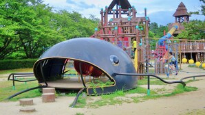 A playground with a large whale play structure, a wooden climbing frame, and a slide. - Polaris (Takashima)