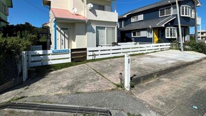 Zona residencial con dos casas, una con techo rojo y otra con fachada azul oscuro.