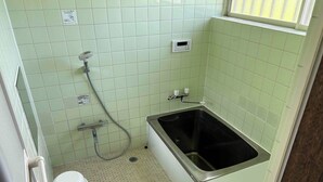 Un baño pequeño con bañera, inodoro y ducha.