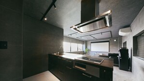 Una cocina moderna con armarios oscuros, una isla grande y un horno empotrado.