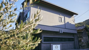 Un edificio moderno con techo plano, un amplio portón de garaje y un letrero con un escudo.