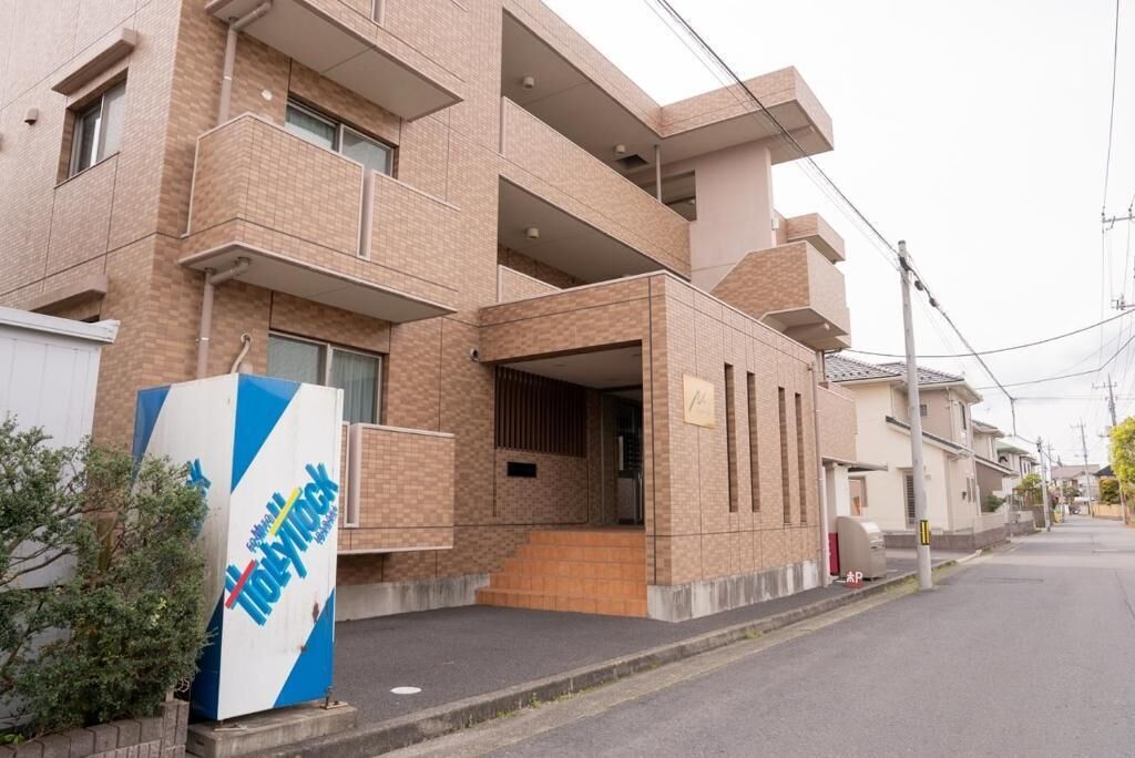 A multi-story building with a prominent sign, a gated entrance, and a visible outdoor area.