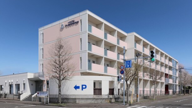 A multi-story hotel building with a sign reading 'HOTEL 7s Anchorage.'