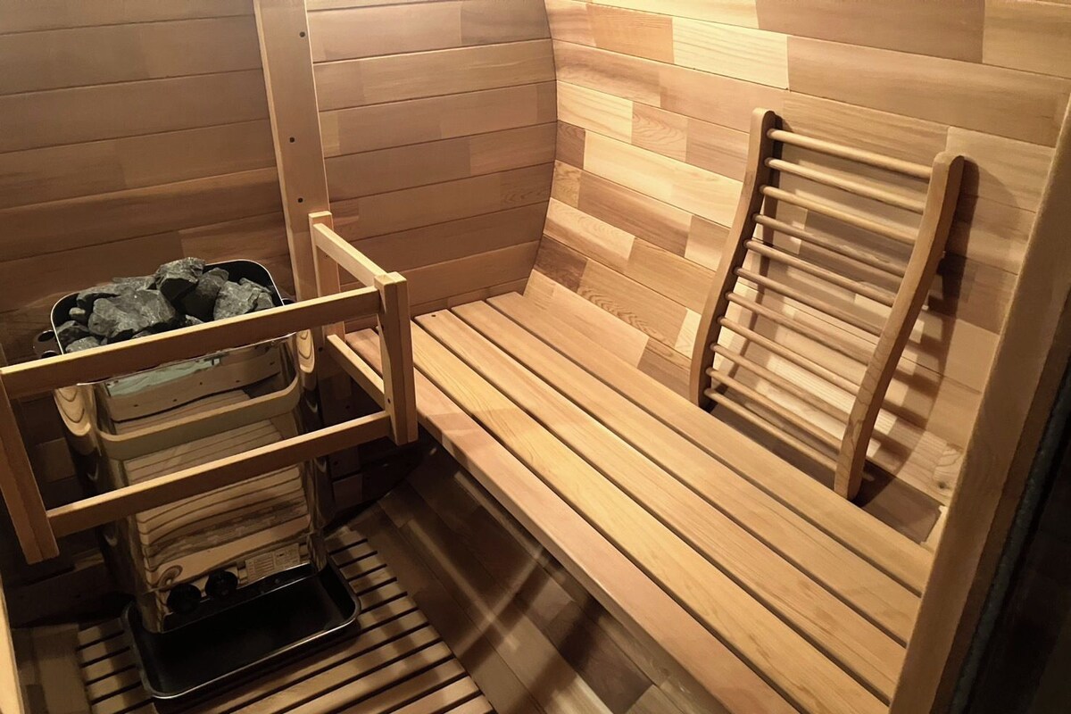 A sauna room with wooden benches and a bench with a towel rack.