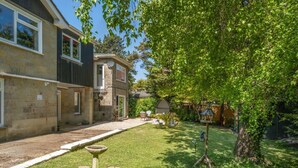 A residential property with a stone facade, a small garden with a birdbath, and a tree providing shade. - 1 Bed in Sandown (oc-85248) (Sandown)