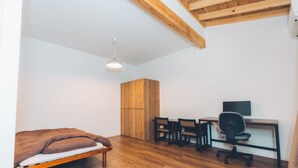 A bedroom with a bed, wooden wardrobe, desk, chairs, and a computer. - Tsumugiyado Fuji (Fujieda)