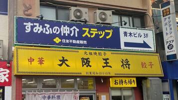A commercial building with multiple signs, including one for a restaurant and another for a service.