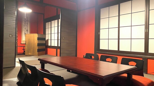 Ein traditioneller japanischer Raum mit Tatami-Böden, einem niedrigen Tisch und Shoji-Schiebebildschirmen.