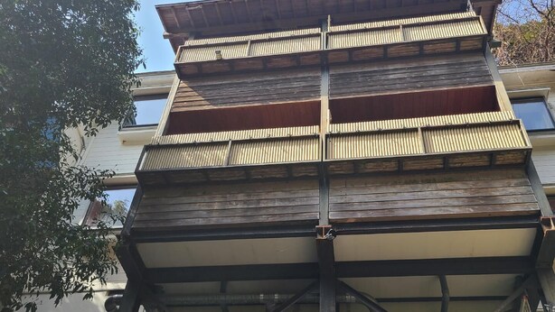 A multi-story building with a wooden facade and a metal framework. - Usui (Nishiizu)