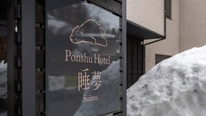 A sign for the Ponshu Hotel with Japanese characters and a cloud graphic.