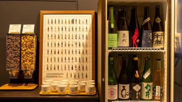 A display of various Japanese snacks and beverages, including a framed menu and a selection of sake bottles.