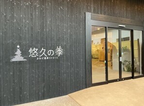 A building with a dark wooden facade and a glass entrance.